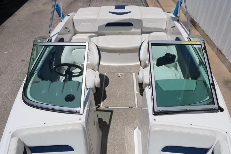 Slide: The Image of 2013 Chaparral 19 Sport H2O boat interior with white seating and dual consoles. - 15