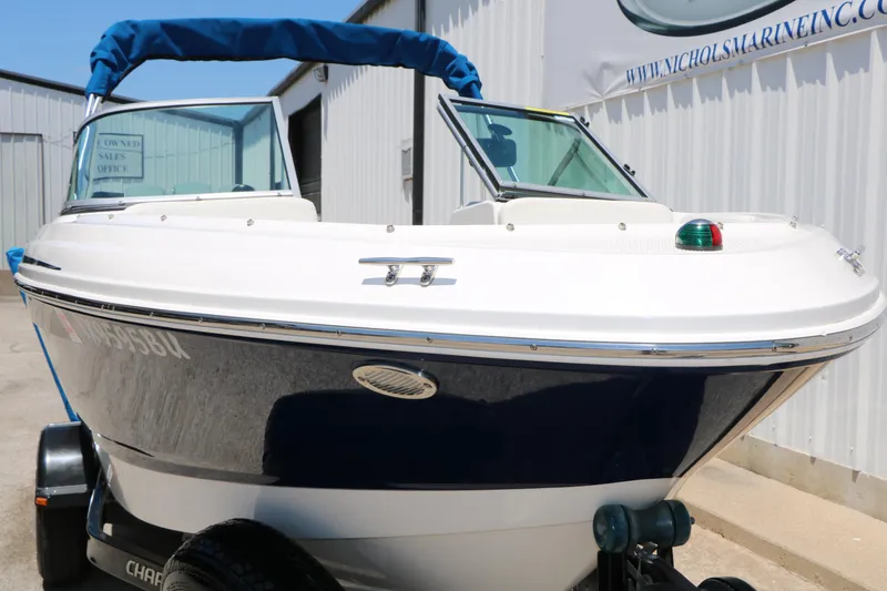 Slide: The Image of 2013 Chaparral 19 Sport H2O boat with blue canopy, parked on trailer. - 6