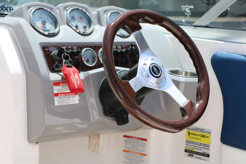 Slide: The Image of Steering wheel and dashboard of 2013 Chaparral 19 Sport H2O boat, featuring gauges and controls. - 18