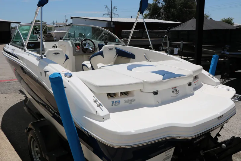 Slide: The Image of 2013 Chaparral 19 Sport H2O boat with white and blue interior, parked on a trailer. - 38