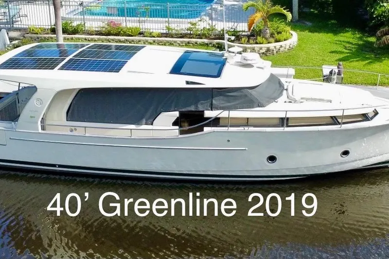 The Image of 2019 Greenline 40 Hybrid yacht with solar panels, docked by a lush garden. - 0
