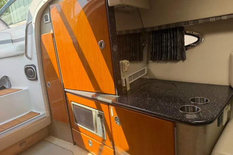 Slide: The Image of 2006 Formula 330 Sun Sport cabin interior with kitchenette and wooden cabinetry. - 20