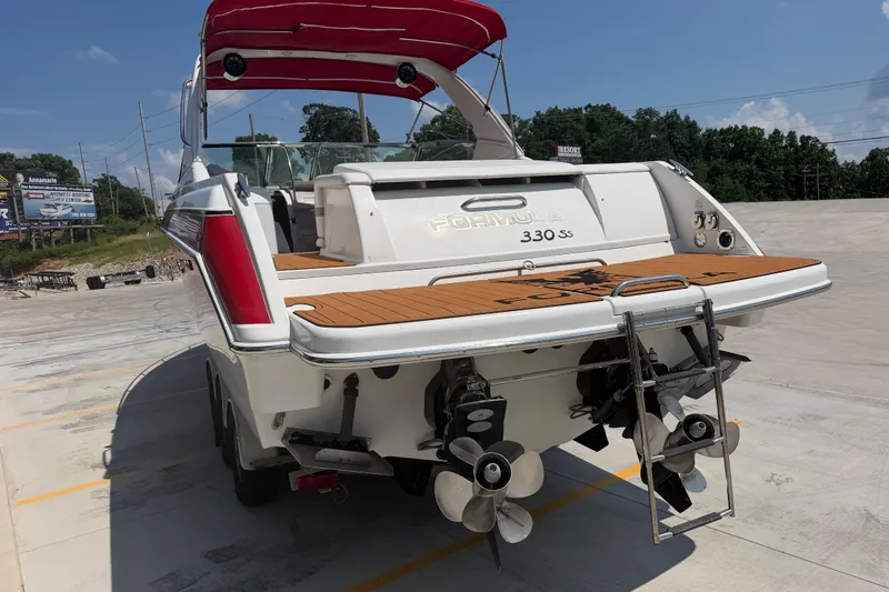 Slide: The Image of 2006 Formula 330 Sun Sport boat with dual propellers and swim platform, parked outdoors. - 5