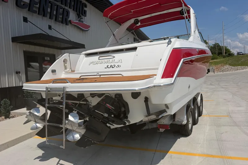 Slide: The Image of 2006 Formula 330 Sun Sport boat on trailer, red and white design, outside a boating center. - 4