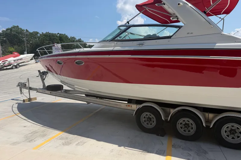 Slide: The Image of 2006 Formula 330 Sun Sport boat on trailer, red and white design, parked outdoors. - 8