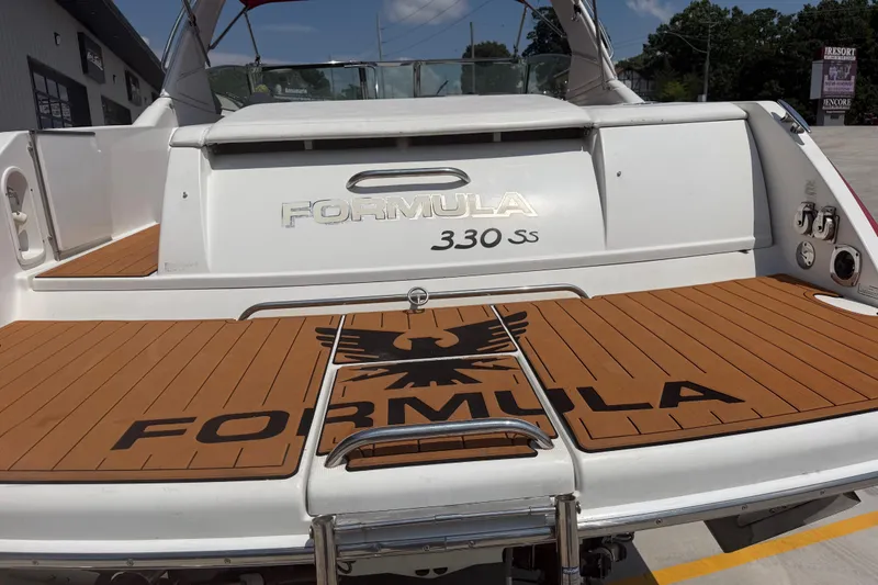Slide: The Image of 2006 Formula 330 Sun Sport boat with teak deck and logo, docked outdoors. - 10