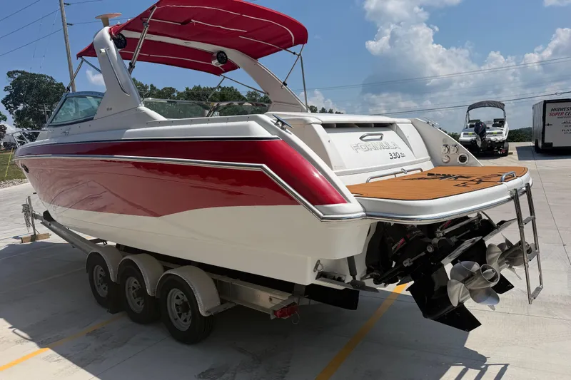 Slide: The Image of 2006 Formula 330 Sun Sport boat with red and white exterior on a trailer. - 6