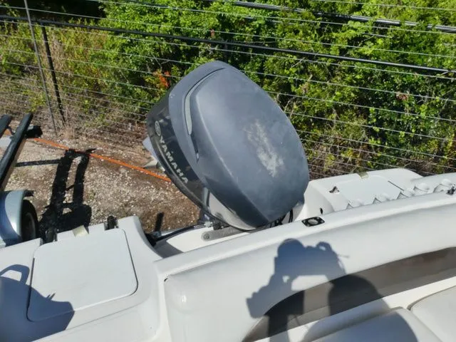 Slide: The Image of An outboard motor on a boat, surrounded by green vegetation and a fence. - 5