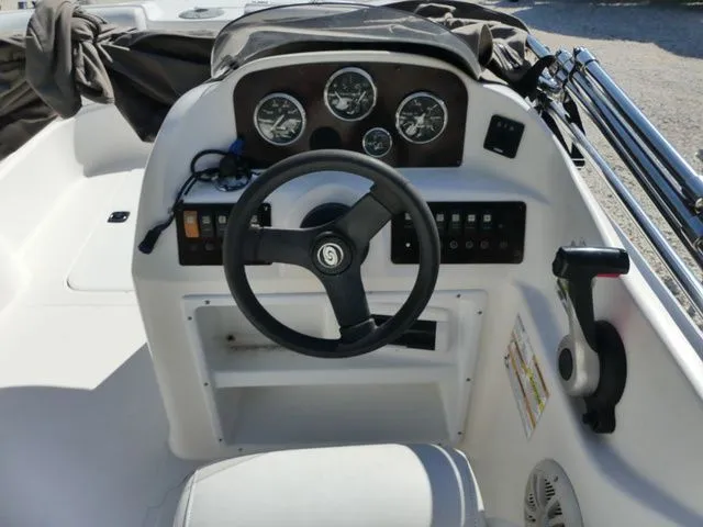 Slide: The Image of The image shows the helm of a 2012 Hurricane Sundeck 188 boat with a steering wheel and gauges. - 8