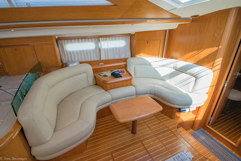 Slide: The Image of Interior of the 2006 Jeanneau Sun Odyssey 54 DS with curved leather sofa and wooden table. - 10