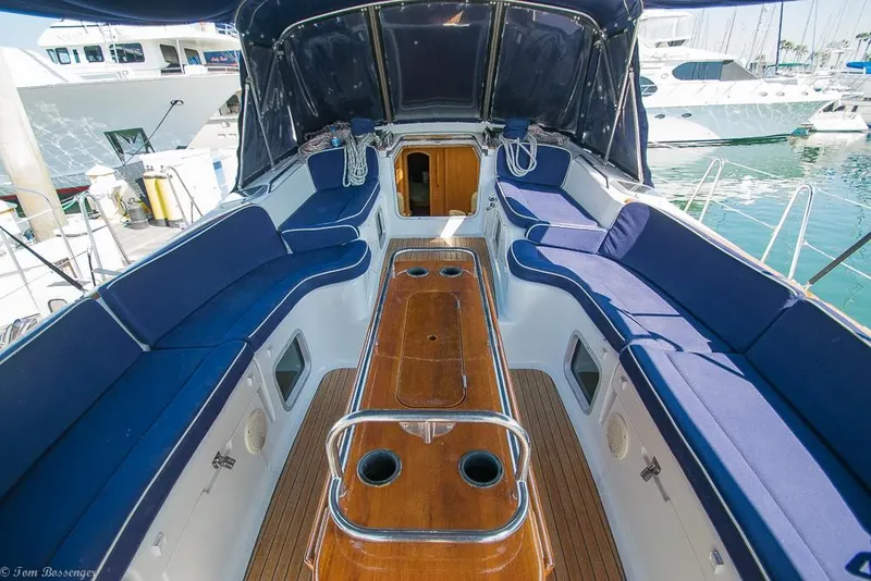Slide: The Image of The image shows the cockpit of a 2006 Jeanneau Sun Odyssey 54 DS with blue cushions and wooden flooring. - 46