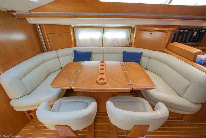 Slide: The Image of The interior of the 2006 Jeanneau Sun Odyssey 54 DS features an elegant seating area with a wooden table. - 8