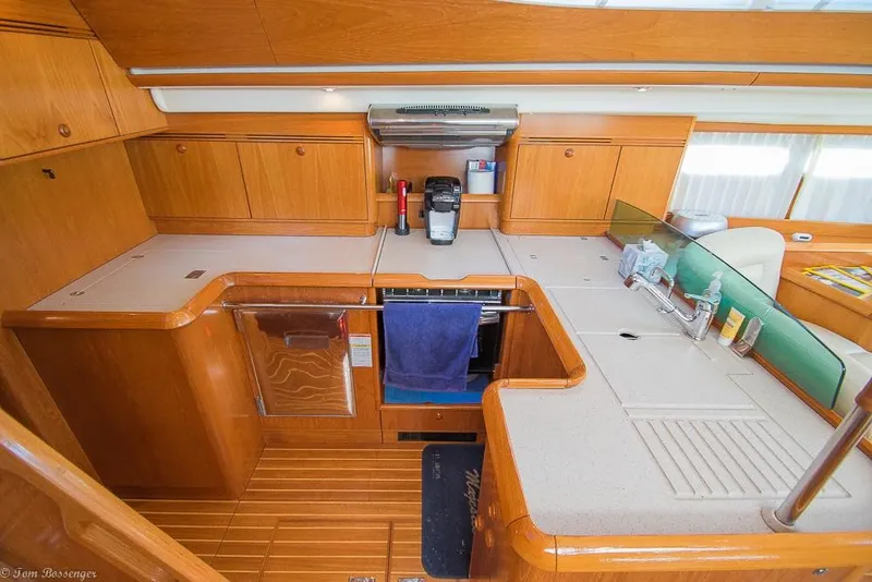 Slide: The Image of The 2006 Jeanneau Sun Odyssey 54 DS galley features wooden cabinets and modern appliances. - 13