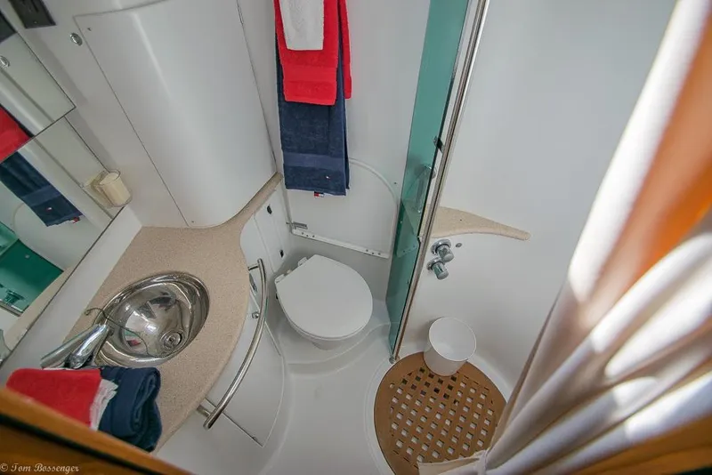 Slide: The Image of The image shows a boat bathroom with a sink, toilet, and shower. - 22