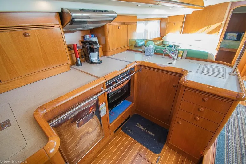 Slide: The Image of The galley of a 2006 Jeanneau Sun Odyssey 54 DS with wooden cabinets and modern appliances. - 14