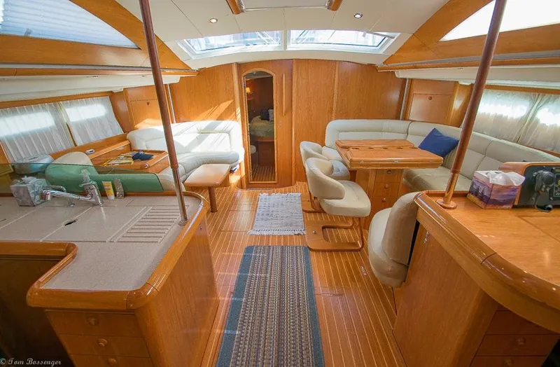 Slide: The Image of The interior of a 2006 Jeanneau Sun Odyssey 54 DS features a spacious cabin with wood finishes. - 1