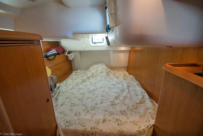 Slide: The Image of The cabin of a 2006 Jeanneau Sun Odyssey 54 DS with a cozy bed and wood paneling. - 35
