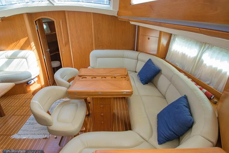 Slide: The Image of Interior of a 2006 Jeanneau Sun Odyssey 54 DS with elegant seating area and wooden table. - 3