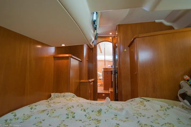 Slide: The Image of Interior of a 2006 Jeanneau Sun Odyssey 54 DS with wood paneling and a cozy bed. - 36