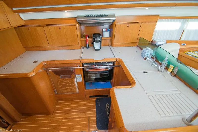 Slide: The Image of The 2006 Jeanneau Sun Odyssey 54 DS galley features wooden cabinets and modern appliances. - 17