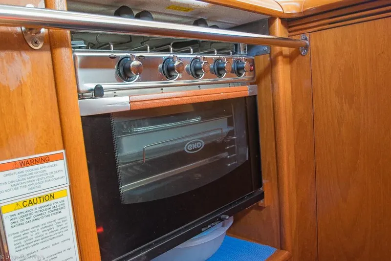 Slide: The Image of The 2006 Jeanneau Sun Odyssey 54 DS galley features a built-in ENO oven with wooden cabinetry. - 15