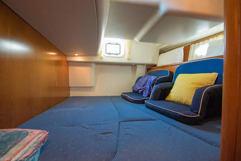 Slide: The Image of The cabin of the 2006 Jeanneau Sun Odyssey 54 DS features a cozy bed with blue cushions. - 33