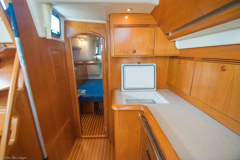 Slide: The Image of Interior view of a 2006 Jeanneau Sun Odyssey 54 DS with wooden cabinetry and a kitchenette. - 32