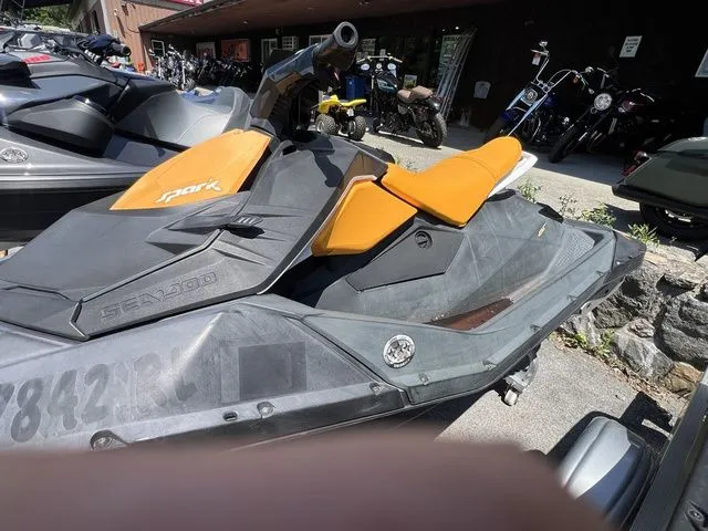 Slide: The Image of A Sea-Doo Spark 2-Up jet ski with orange seating is parked on a lot. - 3