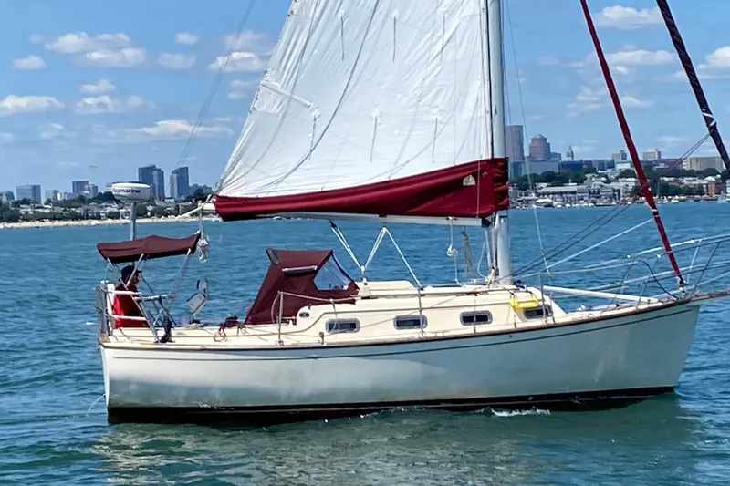 Slide: The Image of Sailing yacht Island Packet 27, 1990 model, cruising on a sunny day near city skyline. - 2