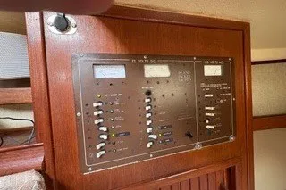 Slide: The Image of Electrical panel on a 1990 Island Packet 27 sailboat, featuring switches and gauges. - 20