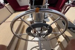 Slide: The Image of Steering wheel of a 1990 Island Packet 27 sailboat with beige and red seating. - 7