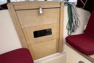 Slide: The Image of 1990 Island Packet 27 sailboat interior with wooden hatch and red seating. - 58
