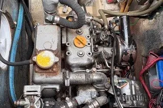 Slide: The Image of Engine compartment of a 1990 Island Packet 27 sailboat, showing mechanical components and wiring. - 41