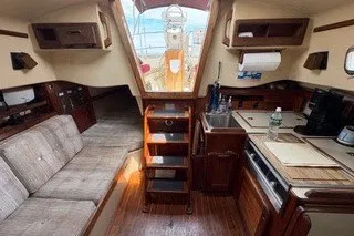 Slide: The Image of Interior of a 1990 Island Packet 27 sailboat, featuring a cozy cabin and kitchenette. - 6
