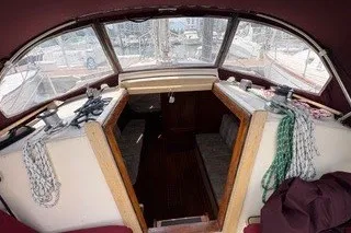 Slide: The Image of 1990 Island Packet 27 sailboat cockpit with ropes and seating area. - 4
