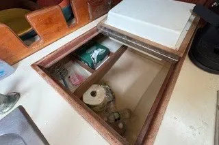 Slide: The Image of Storage compartment on a 1990 Island Packet 27 sailboat, featuring various items. - 23