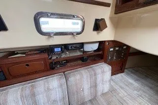 Slide: The Image of Interior of a 1990 Island Packet 27 sailboat, featuring a cozy cabin with wood accents. - 29