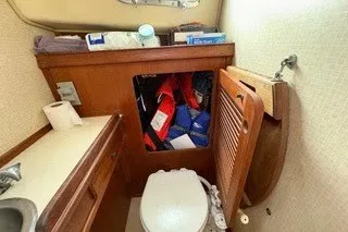 Slide: The Image of 1990 Island Packet 27 sailboat bathroom with storage, sink, and toilet. - 33