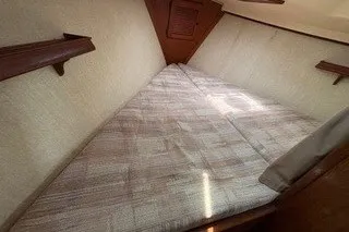 Slide: The Image of 1990 Island Packet 27 interior cabin with a cozy V-berth bed. - 27