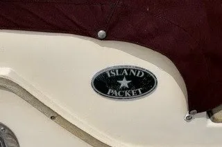 Slide: The Image of 1990 Island Packet 27 sailboat logo on cream-colored hull. - 18
