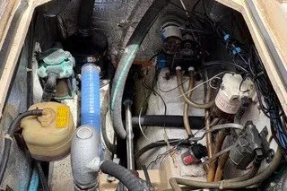 Slide: The Image of Engine compartment of a 1990 Island Packet 27 sailboat, showing various mechanical components. - 42