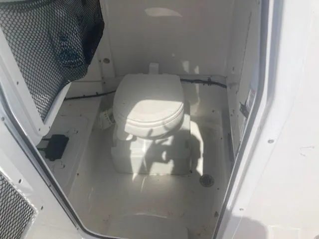 Slide: The Image of The image shows a toilet inside a boat, surrounded by white walls and a mesh pocket. - 9