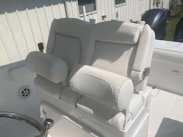 Slide: The Image of Two cushioned seats on a boat with white upholstery and armrests. - 5