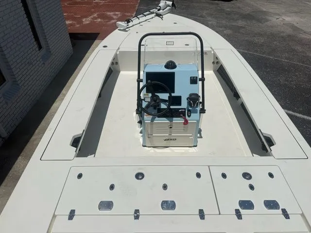 Slide: The Image of 2027 Hewes Redfisher 21 with open deck and helm console, parked on a lot. - 9