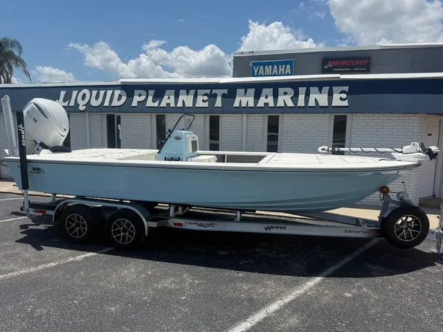 The Image of A Hewes Redfisher 21 boat on a trailer in front of a marine store. - 1