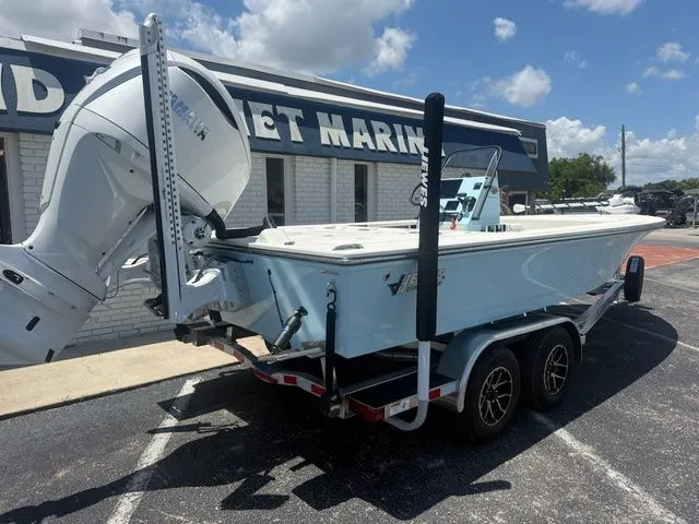 Slide: The Image of A 2027 Hewes Redfisher 21 on a trailer in front of a building, featuring a large outboard motor. - 4