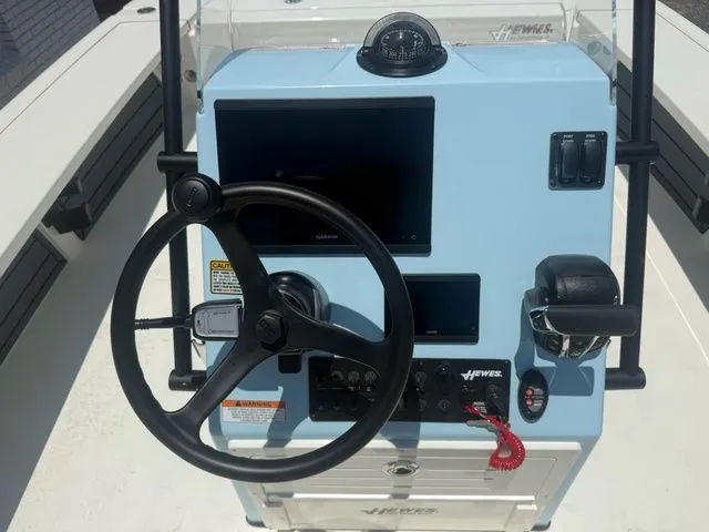 Slide: The Image of The image shows the helm of a Hewes Redfisher 21 boat with a steering wheel and instruments. - 12
