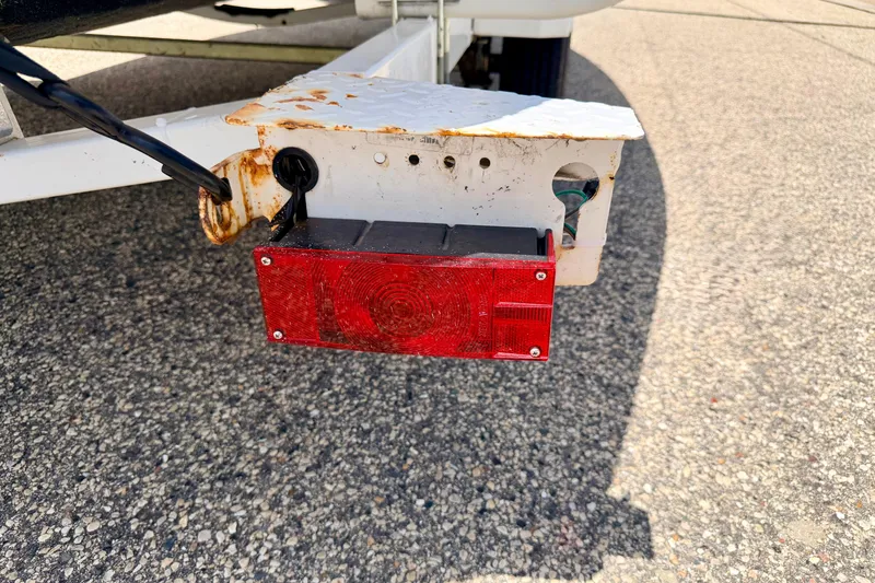 Slide: The Image of Rusty trailer light on a 2004 Bombardier SEADOO Utopia 185, parked on asphalt. - 57