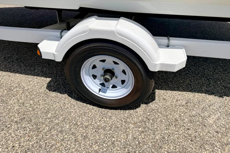 Slide: The Image of Trailer wheel of a 2004 Bombardier SEADOO Utopia 185 on asphalt surface. - 49