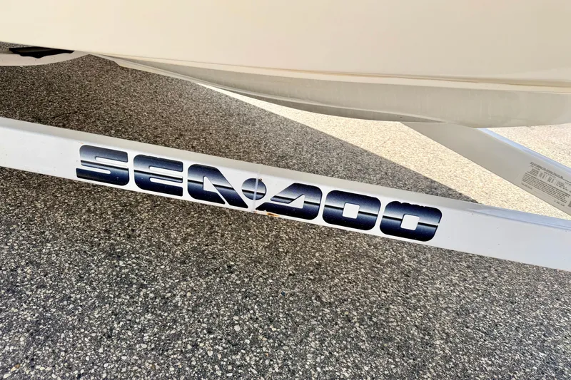 Slide: The Image of 2004 Bombardier SEADOO Utopia 185 trailer on asphalt, featuring bold logo. - 54